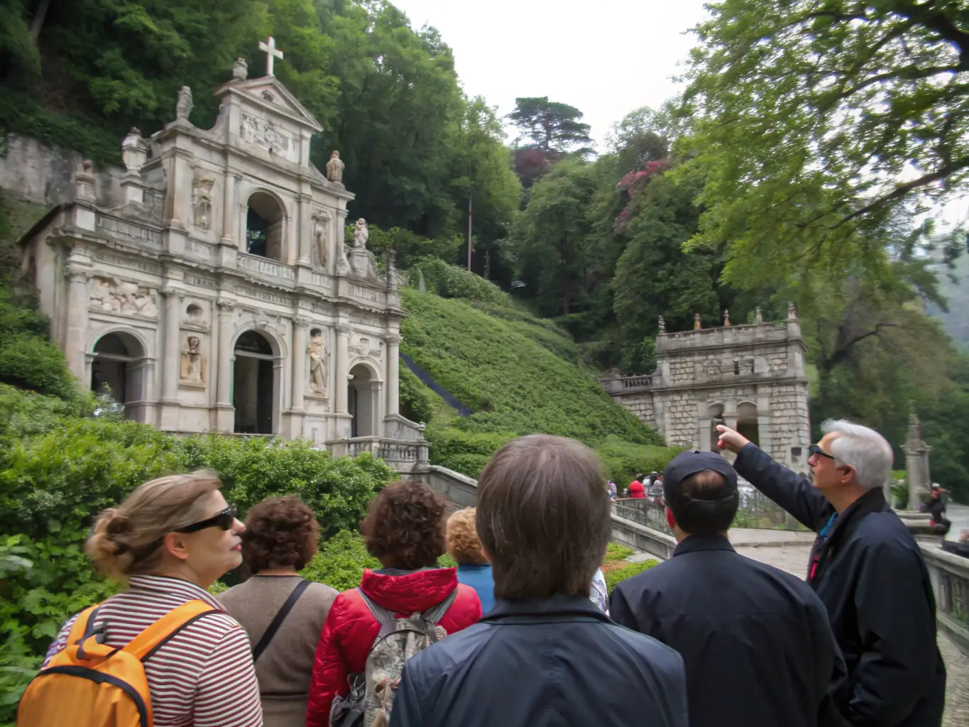 An image showing a group of CALLIOPE CULTURE volunteers leading a heritage tour of a historical site, with participants listening attentively and engaging with the guide. The setting is a well-preserved historical landmark.